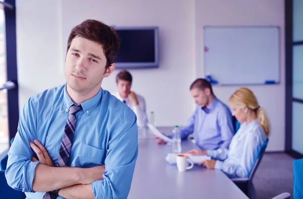 Uomo d'affari in un incontro in ufficio con i colleghi nel backgroun — Foto Stock