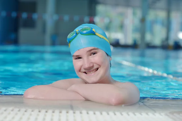 Mujer bonita con gorra de natación y gafas de natación en la piscina