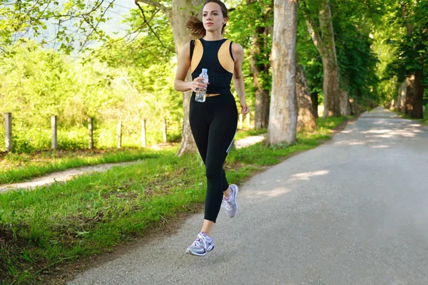 Ung vacker kvinna jogga på morgonen i parken — Stockfoto