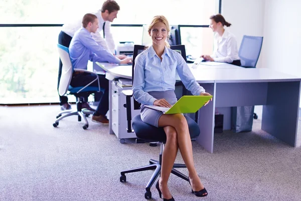 Podnikání žena s její zaměstnanci v pozadí v kanceláři — Stock fotografie