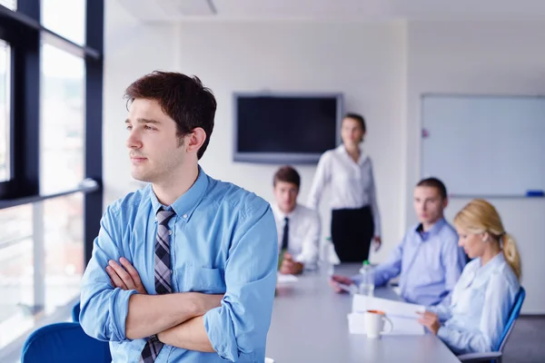 Uomo d'affari in un incontro in ufficio con i colleghi nel backgroun — Foto Stock