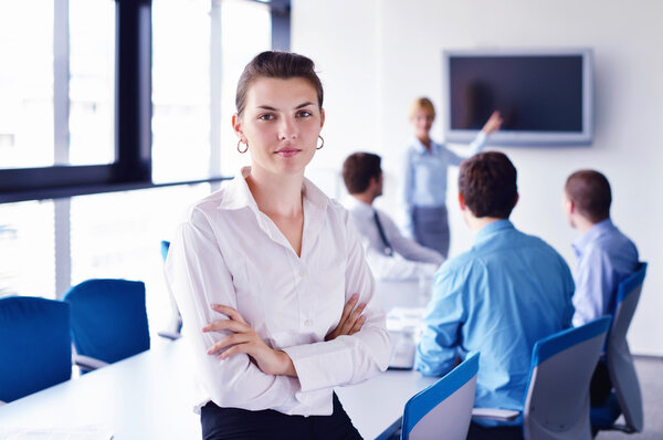 business woman with her staff in background at office