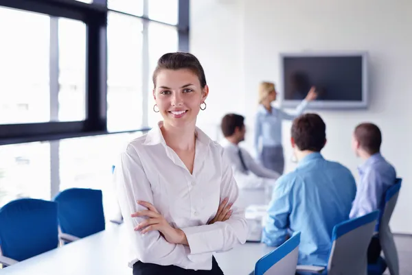 Zakenvrouw met haar personeel op achtergrond op kantoor — Stockfoto