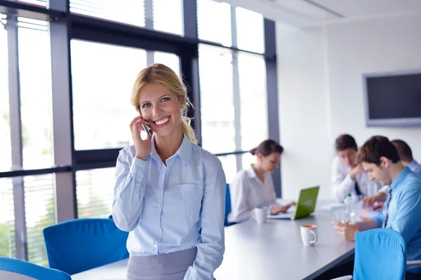 Donna d'affari con il suo personale in background in ufficio — Foto Stock