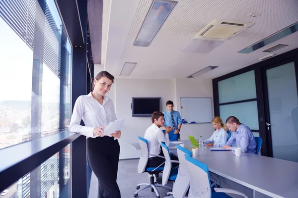 Business woman with her staff in background at office — Stock Photo, Image