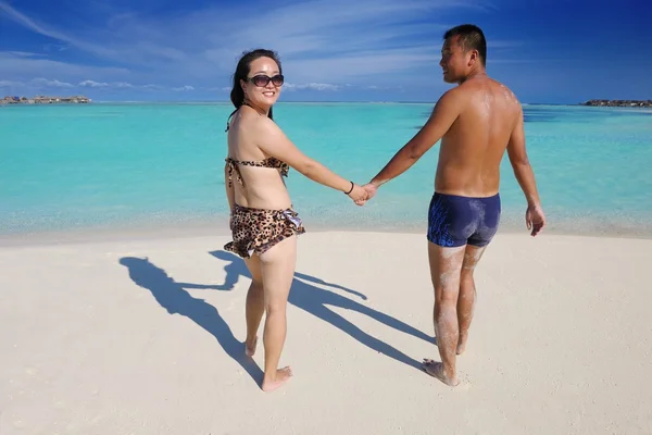 Lyckligt ungt par njuter av sommaren på stranden — Stockfoto