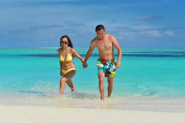 Feliz jovem casal desfrutando de verão na praia — Fotografia de Stock