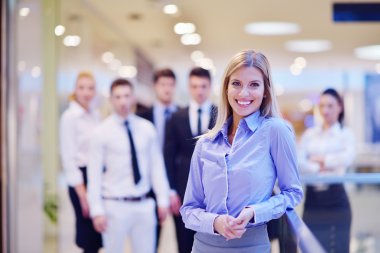 business woman with her staff in background at office clipart