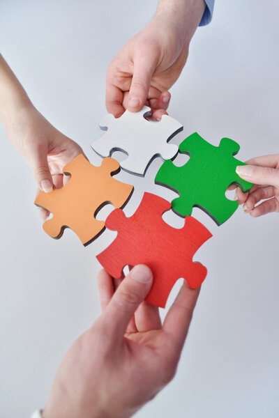 Group of business assembling jigsaw puzzle