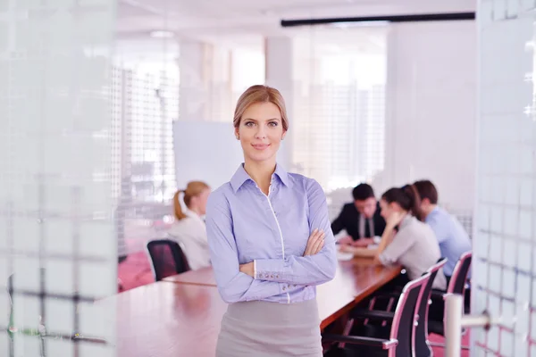 Mujer de negocios con su personal en segundo plano en la oficina — Foto de Stock