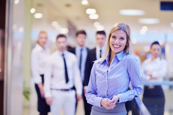 Mujer de negocios con su personal en segundo plano en la oficina — Foto de Stock