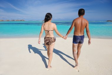 Mutlu genç çift sahilde yazın tadını çıkarıyor.