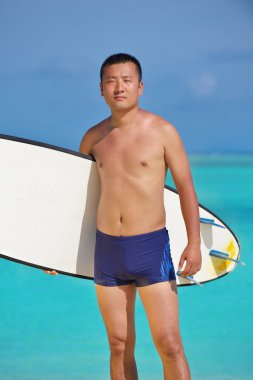 plajda sörf tahtası olan adam