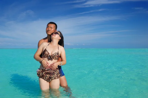 Счастливая молодая пара наслаждается летом на пляже — стоковое фото