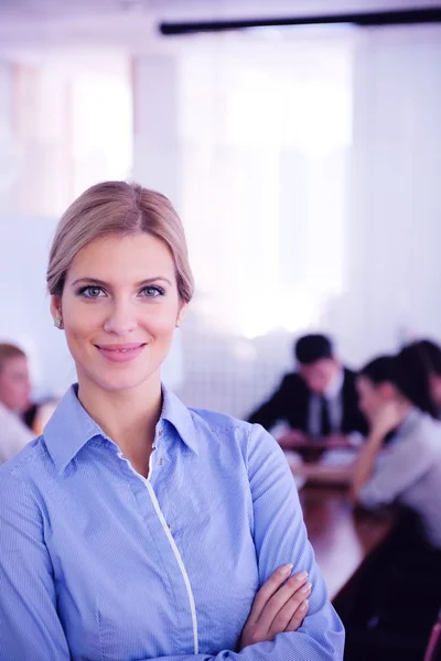 Mujer de negocios con su personal en segundo plano en la oficina — Foto de Stock