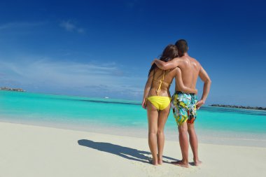 Mutlu genç çift sahilde yazın tadını çıkarıyor.
