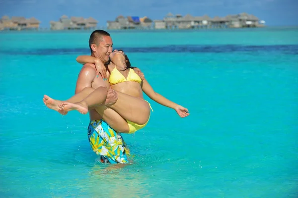 Šťastný mladý pár těší léto na pláži — Stock fotografie