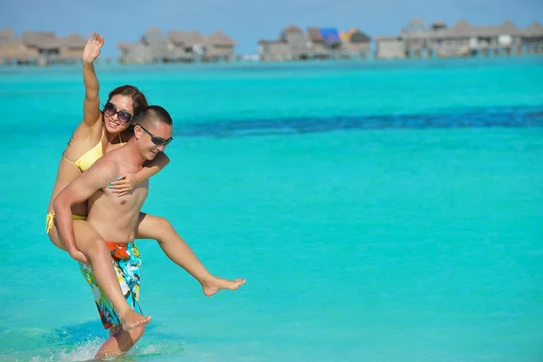 Feliz jovem casal desfrutando de verão na praia — Fotografia de Stock