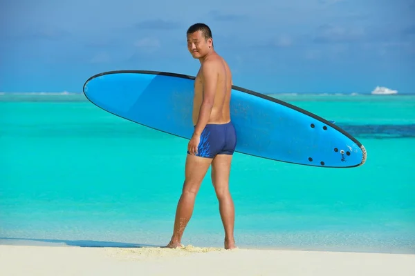 Hombre con tabla de surf en la playa —  Fotos de Stock