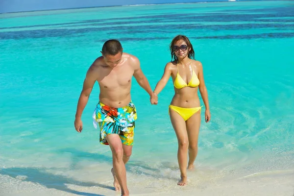 Feliz jovem casal desfrutando de verão na praia — Fotografia de Stock