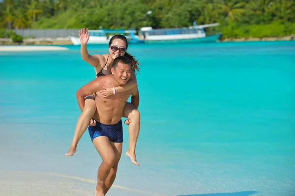 Feliz jovem casal desfrutando de verão na praia — Fotografia de Stock