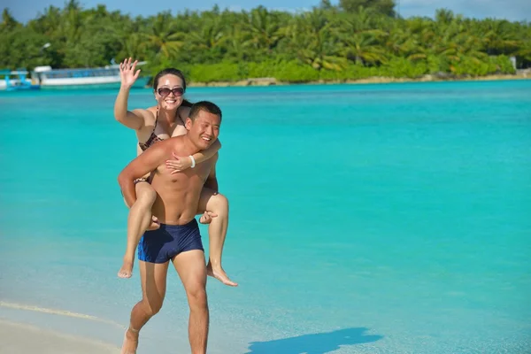 Lyckligt ungt par njuter av sommaren på stranden — Stockfoto