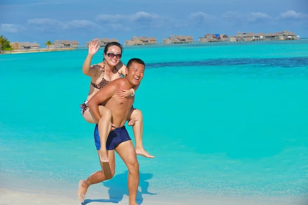 Feliz pareja joven disfrutando del verano en la playa —  Fotos de Stock