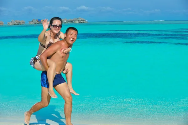 Lyckligt ungt par njuter av sommaren på stranden — Stockfoto