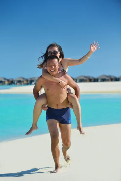 Lyckligt ungt par njuter av sommaren på stranden — Stockfoto