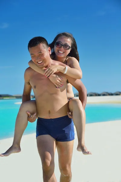 Feliz jovem casal desfrutando de verão na praia — Fotografia de Stock