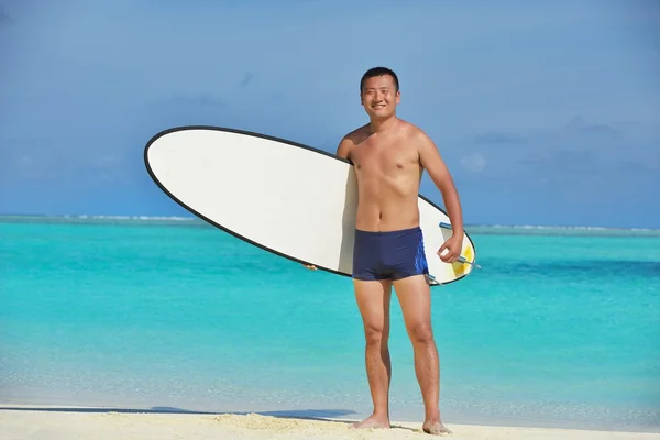 Uomo con tavola da surf sulla spiaggia — Foto Stock