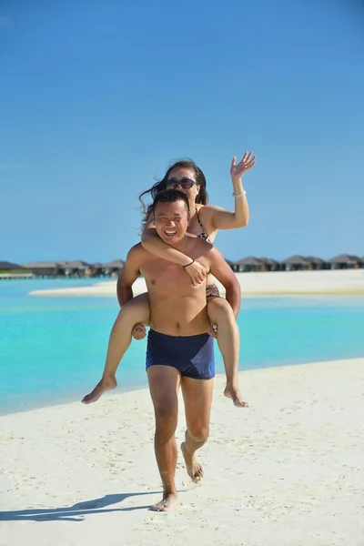 Feliz jovem casal desfrutando de verão na praia — Fotografia de Stock