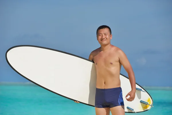 Uomo con tavola da surf sulla spiaggia — Foto Stock