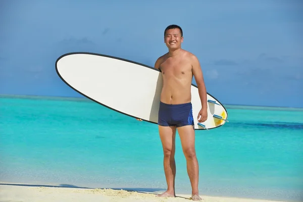 Muž s surfových prken na pláži — Stock fotografie