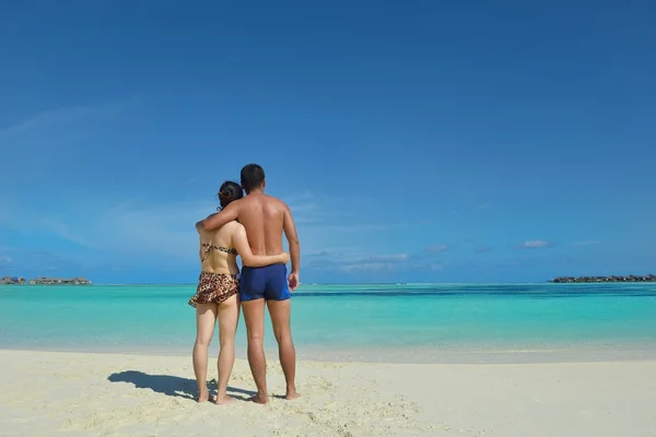 Lyckligt ungt par njuter av sommaren på stranden — Stockfoto