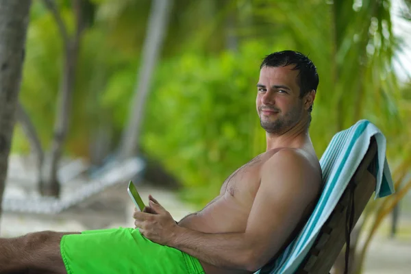 Man ralaxing en gebruik van Tablet PC op strand — Stockfoto