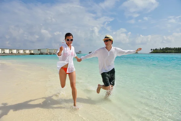 Heureux jeune couple avoir du plaisir sur la plage — Photo