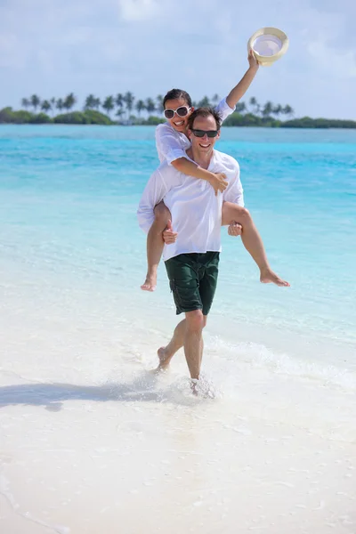 Heureux jeune couple avoir du plaisir sur la plage — Photo