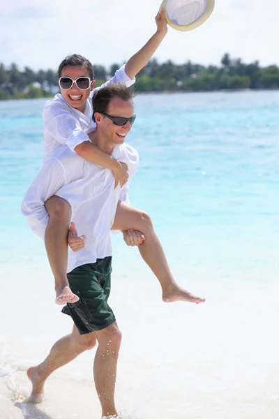 Heureux jeune couple avoir du plaisir sur la plage — Photo