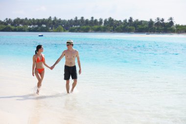 Mutlu genç çift sahilde iyi eğlenceler.