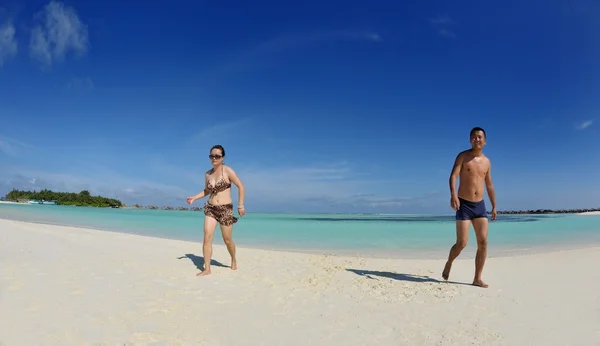 Feliz jovem casal desfrutando de verão na praia — Fotografia de Stock