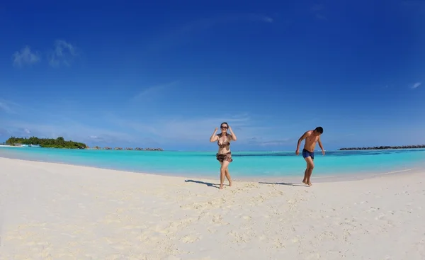 Feliz jovem casal desfrutando de verão na praia — Fotografia de Stock