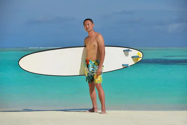 Uomo con tavola da surf sulla spiaggia — Foto Stock