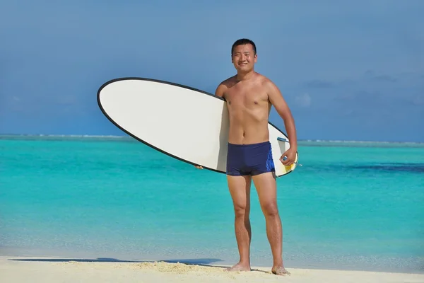 Man med surfbräda på stranden — Stockfoto