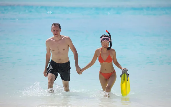 Glada unga par ha kul på stranden — Stockfoto