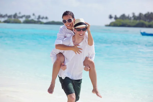 Heureux jeune couple avoir du plaisir sur la plage — Photo