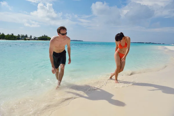 Feliz pareja joven divertirse en la playa — Foto de Stock