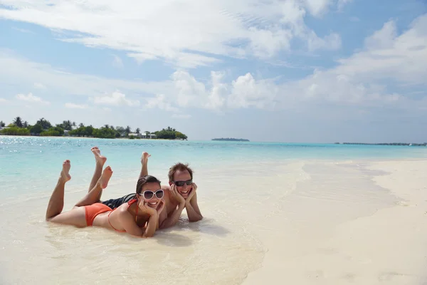 Glada unga par ha kul på stranden — Stockfoto