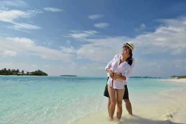 Glada unga par ha kul på stranden — Stockfoto