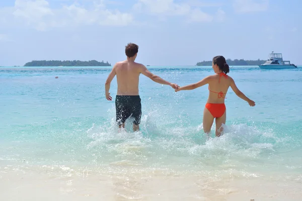 Heureux jeune couple avoir du plaisir sur la plage — Photo